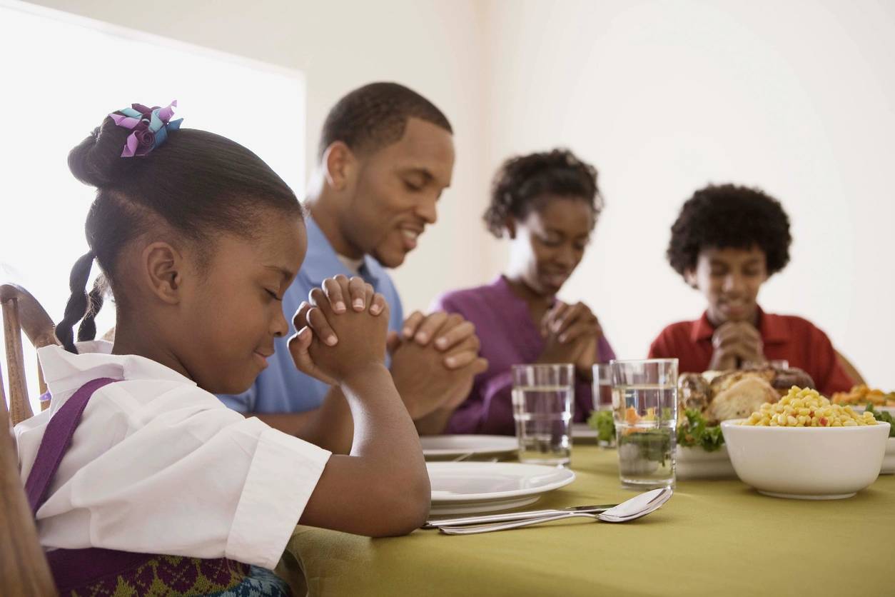 A family praying together, embodying Christian values of faith, love, and unity in their home.